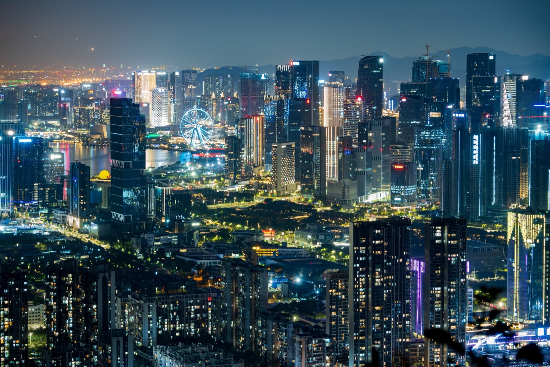 Nocna panorama Shenzhen z podświetlonym diabelskim młynem i wieżowcami